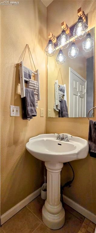 Image 25 of 48: Bathroom with a textured wall and tile patterned floors