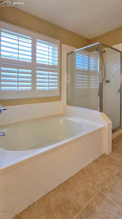 Image 30 of 48: Bathroom featuring a shower stall, a bath, and light tile patterned floors