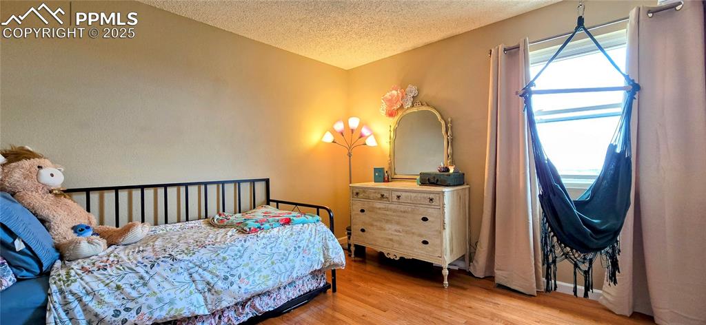 Image 31 of 48: Bedroom featuring light wood-type flooring and a textured ceiling