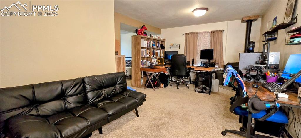 Image 37 of 48: Office featuring carpet flooring and a wood stove