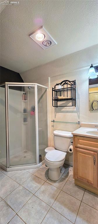 Image 39 of 48: Full bathroom with light tile patterned floors, vanity, a shower stall, and