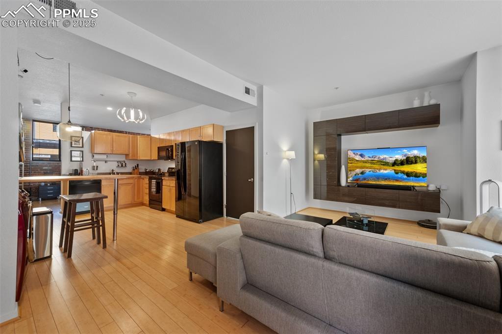 Image 10 of 26: Living area featuring visible vents, light wood-style floors, and a notable