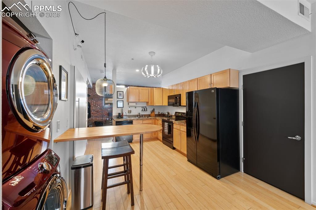 Image 13 of 26: Kitchen featuring light brown cabinets, visible vents, black appliances, st