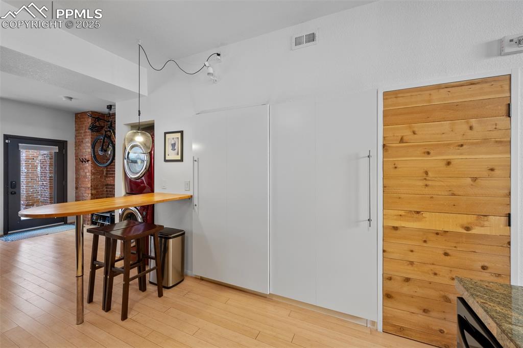 Image 16 of 26: Dining space featuring light wood-style floors and visible vents