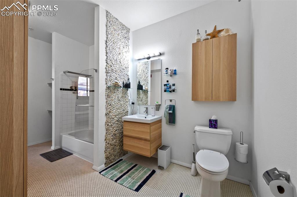 Image 22 of 26: Full bathroom with vanity, toilet, baseboards, and shower / bath combinatio
