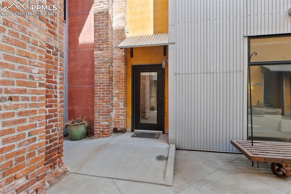 Image 6 of 26: Property entrance with brick siding