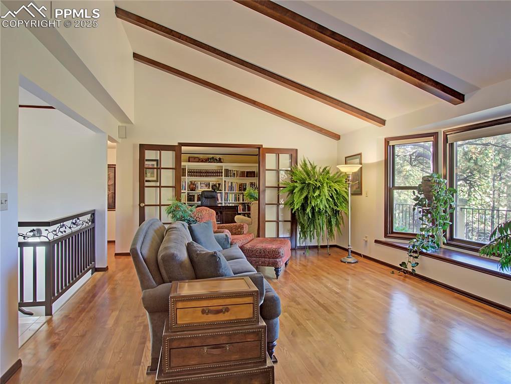 Image 18 of 41: Living area featuring beam ceiling, light wood-style floors, and high vault