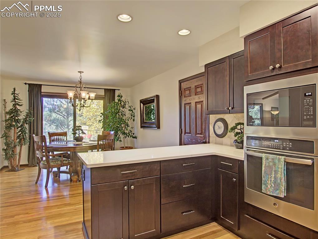 Image 23 of 41: Kitchen with dark brown cabinets, appliances with stainless steel finishes,