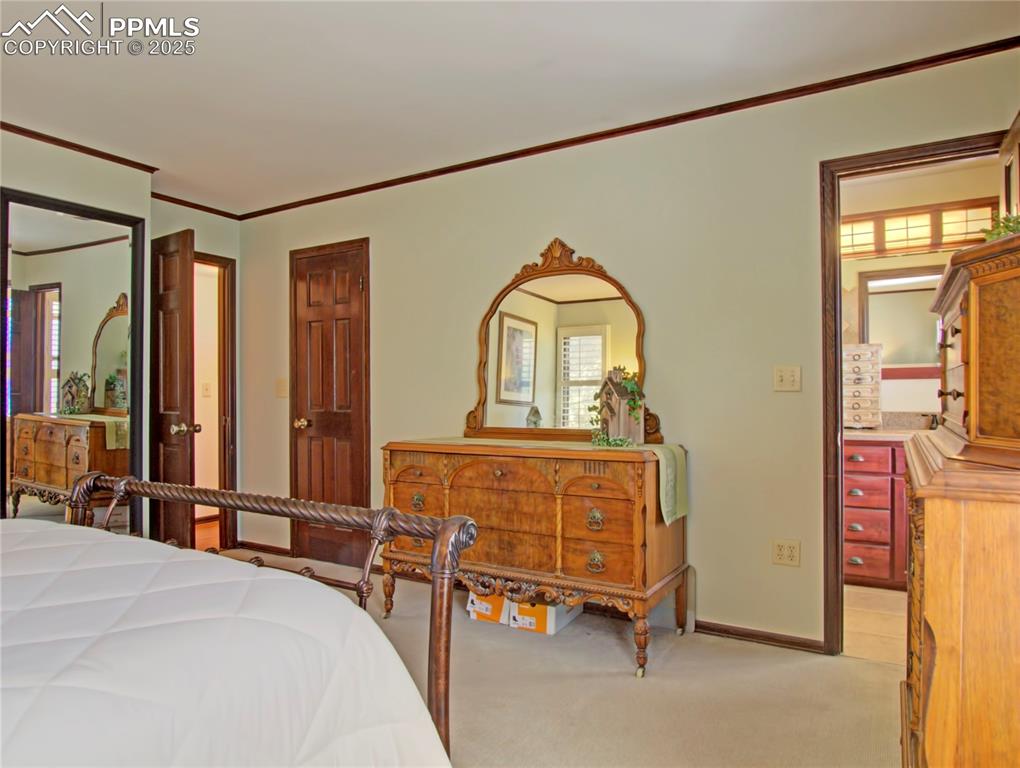 Image 25 of 41: Carpeted bedroom with ornamental molding and baseboards