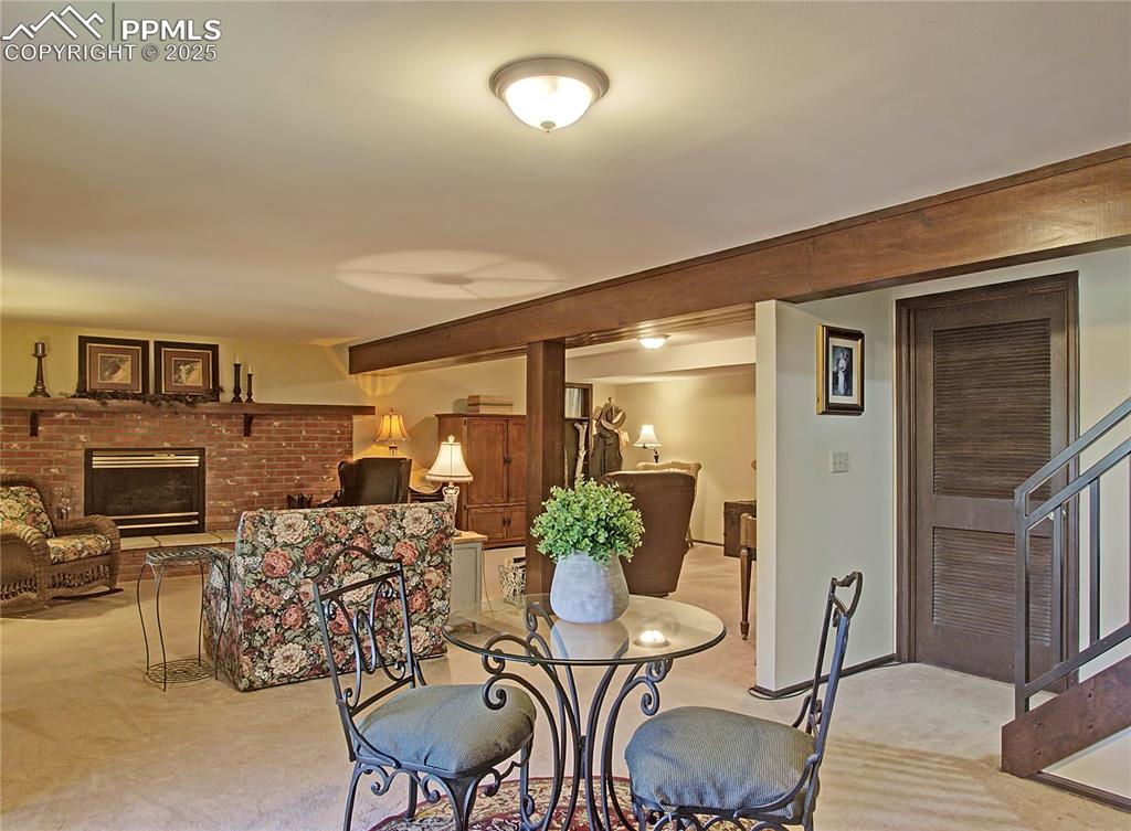 Image 30 of 41: Carpeted dining room with a fireplace and baseboards
