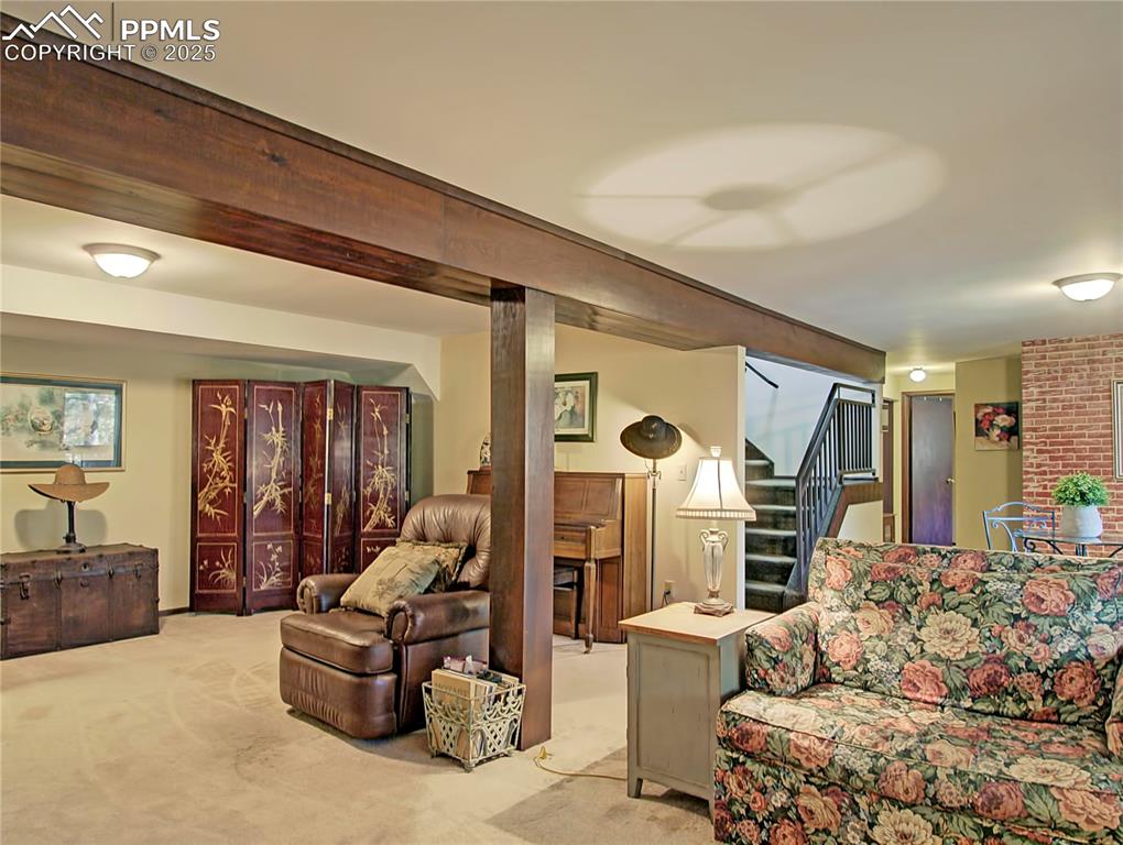 Image 31 of 41: Living room with stairs and light colored carpet