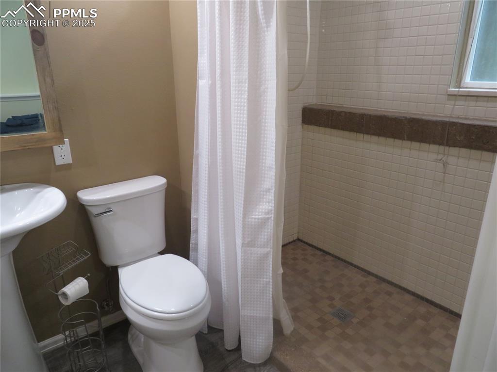 Image 37 of 39: Lower shower room with sink, toilet