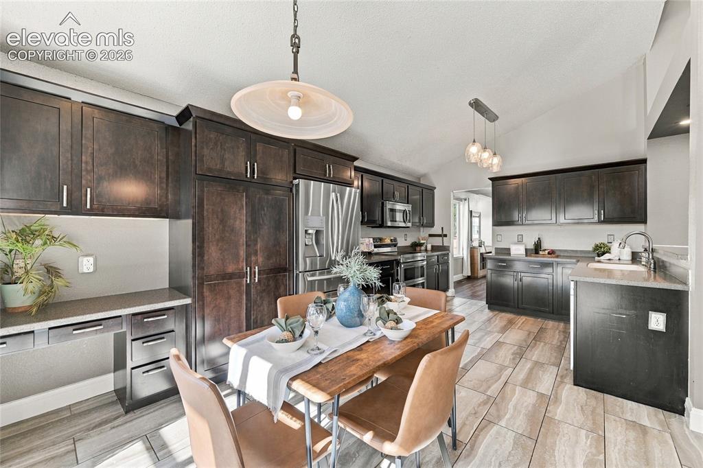 Image 11 of 45: Vaulted ceiling with an overhead light fixture, dark wood-finish cabinetry,