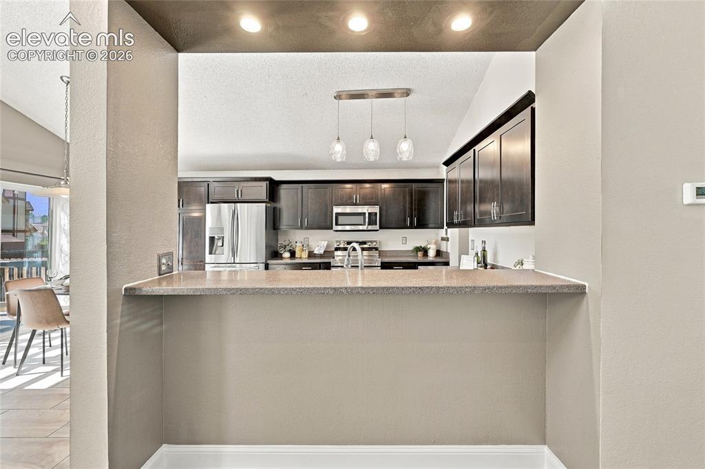 Image 12 of 45: Kitchen pass-through with a solid surface countertop