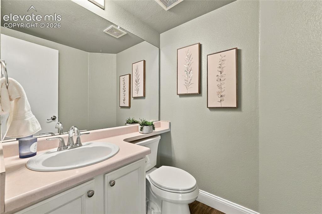 Image 16 of 45: Vanity with integrated sink, chrome faucet, white cabinetry, and full-width