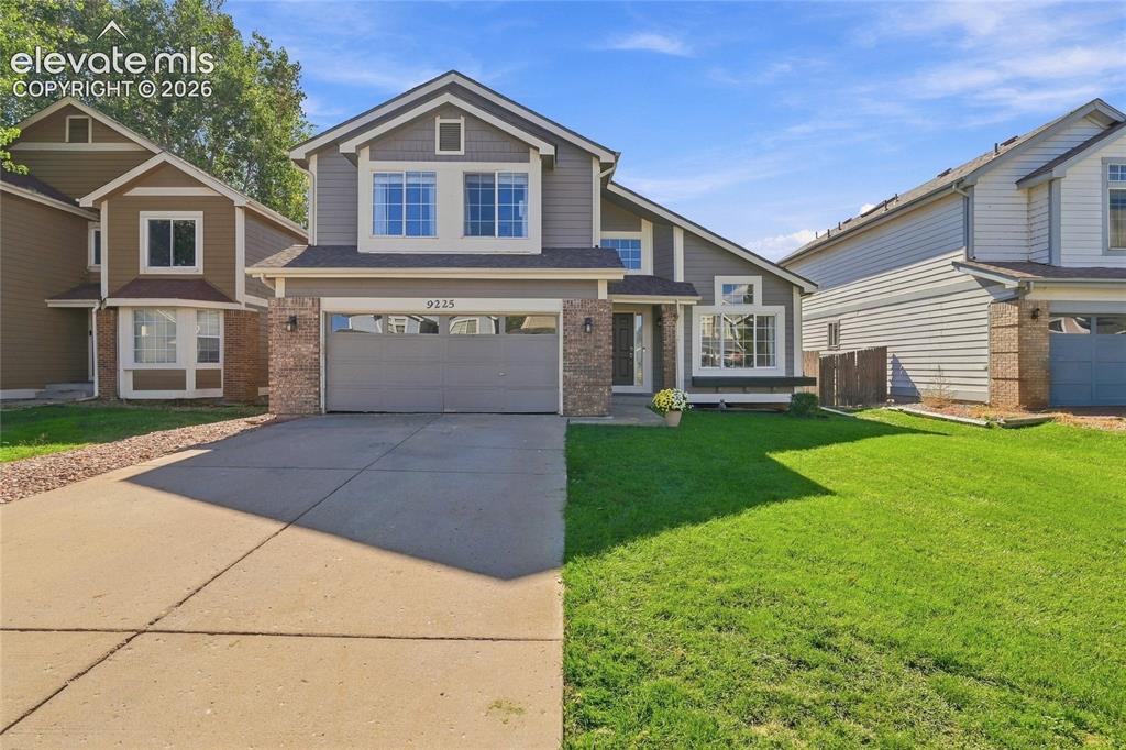 Image 2 of 45: Two-story residence featuring a two-car garage, brick accents, and a concre