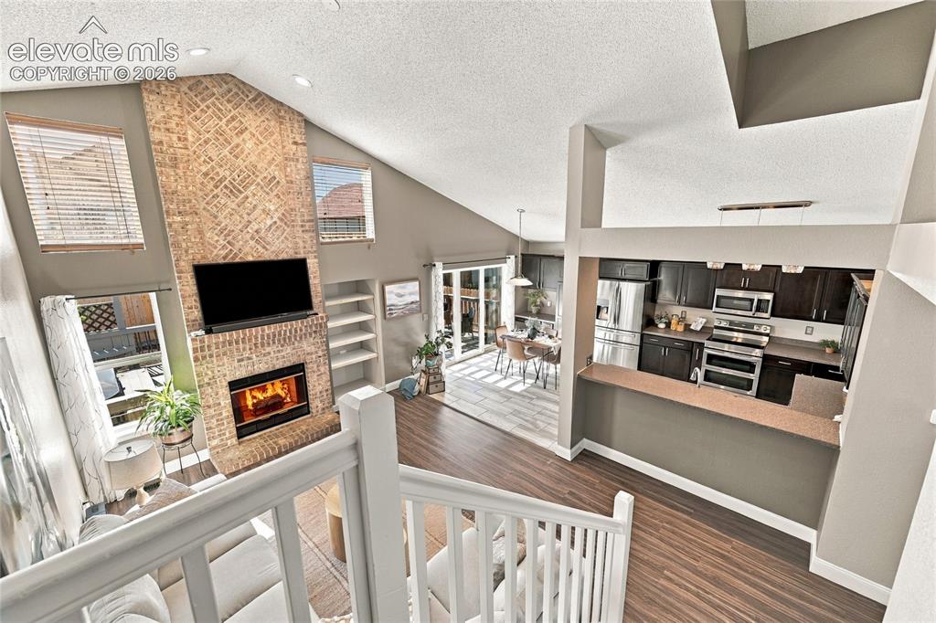 Image 24 of 45: Vaulted ceilings with recessed lighting, brick fireplace with mantel, built