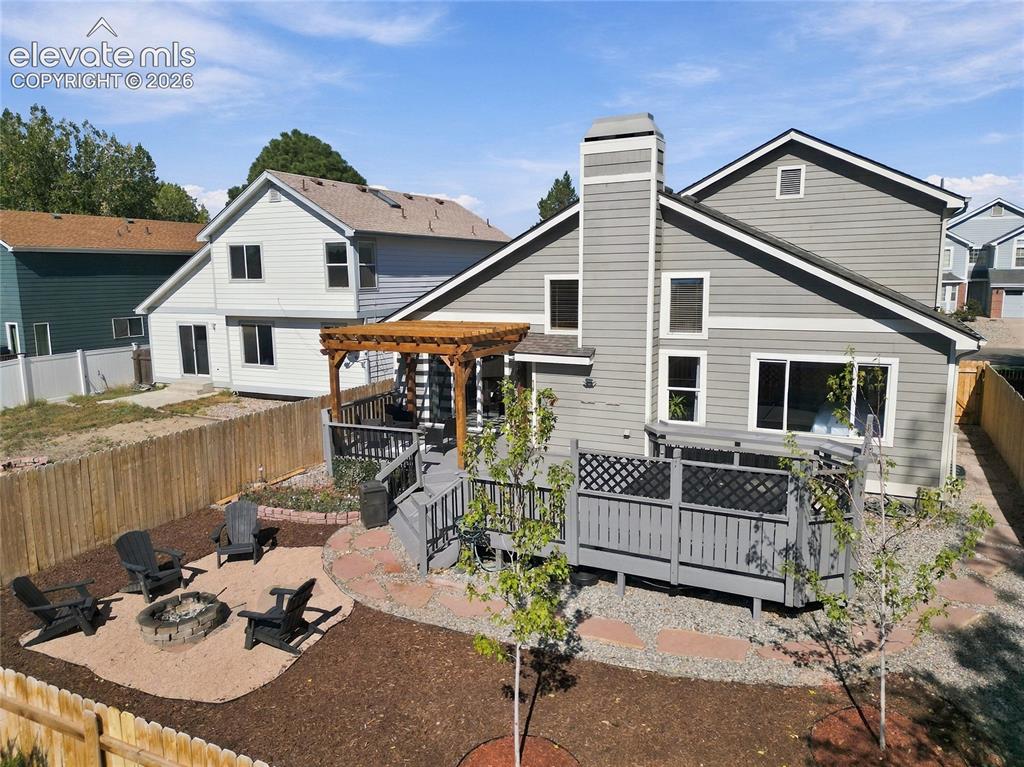 Image 38 of 45: Expansive backyard featuring a multi-level deck, a pergola, a fire pit area