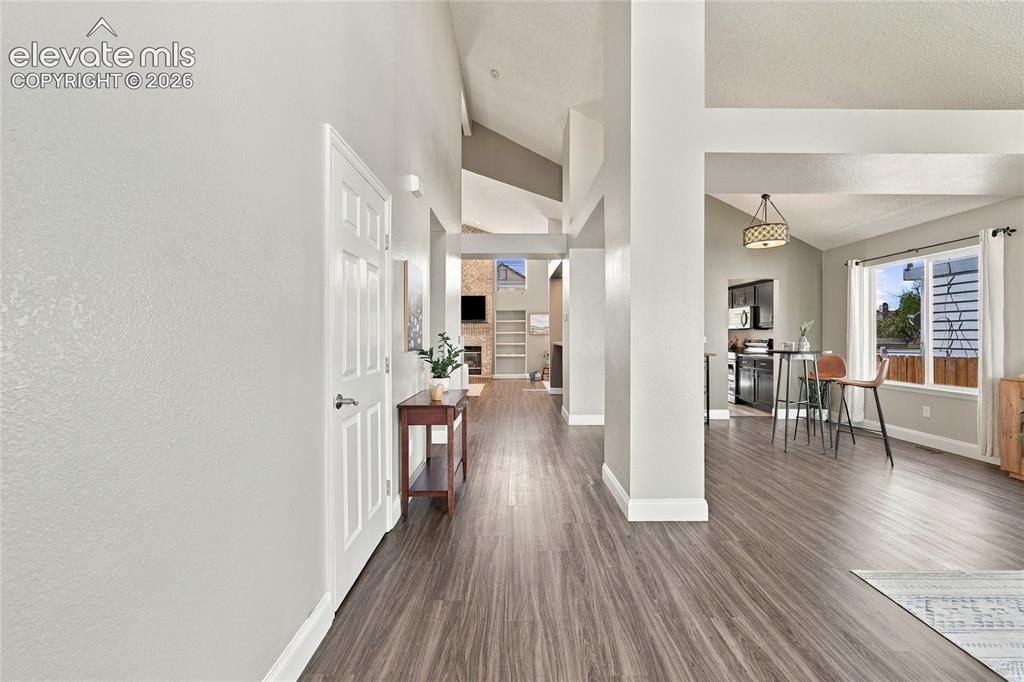 Image 4 of 45: Wood look, vinyl plank flooring throughout, vaulted ceilings, and an open-c