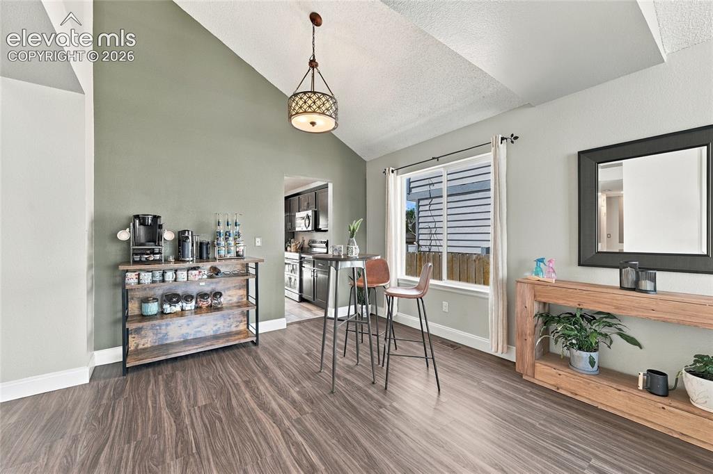 Image 5 of 45: Wood look vinyl plank flooring, vaulted ceiling, recessed window, and overh