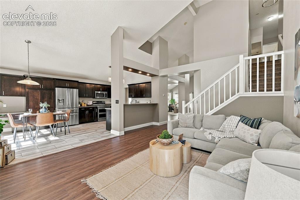 Image 9 of 45: High ceilings, wood look vinyl plank flooring, staircase with white baluste