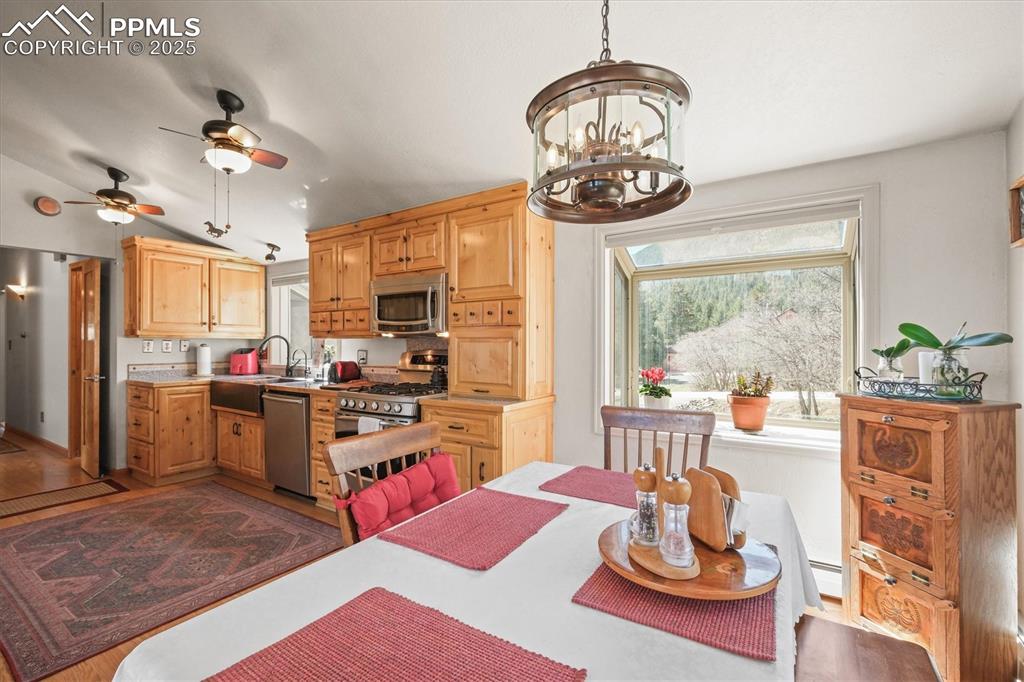 Image 15 of 49: Dining nook featuring a baseboard radiator, vaulted ceiling, garden windows