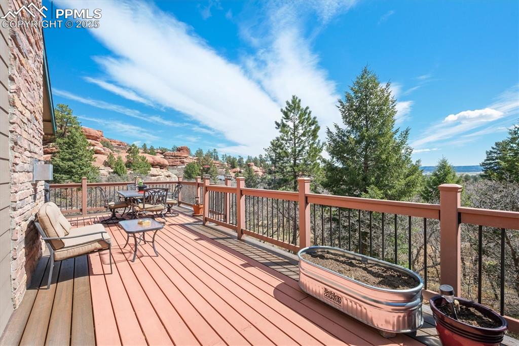 Image 24 of 49: Upper deck off the office slider door with outdoor dining and seating area