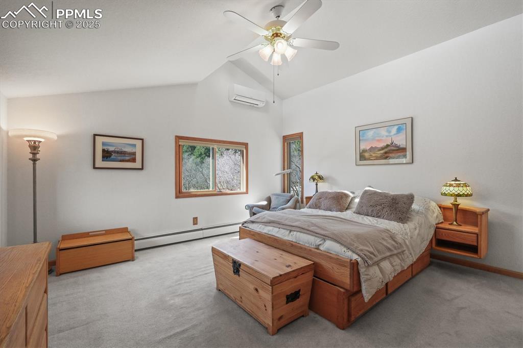 Image 25 of 49: Carpeted bedroom featuring a wall mounted air conditioner, vaulted ceiling,