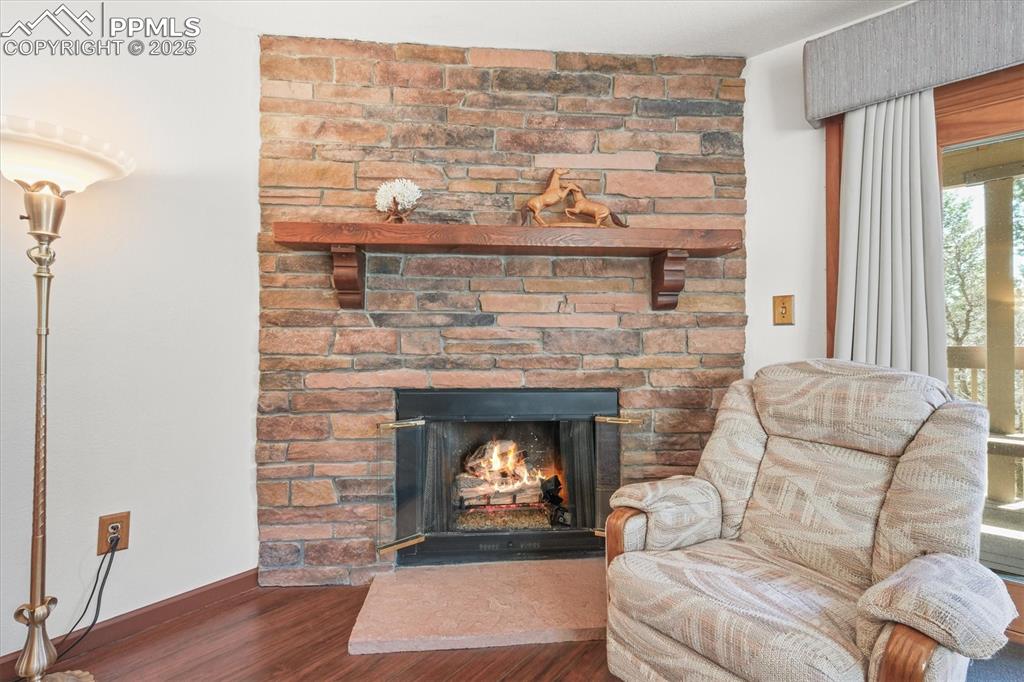 Image 31 of 49: Sitting room featuring a fireplace, wood finished floors, and baseboards