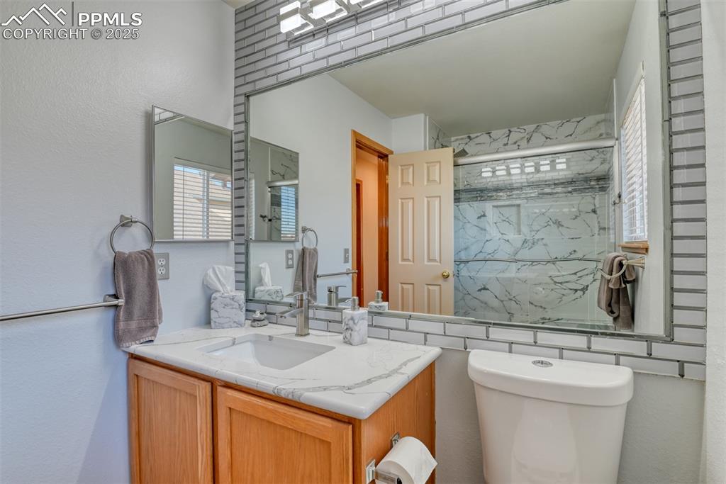 Image 30 of 39: updated hall bath with large walk-in shower