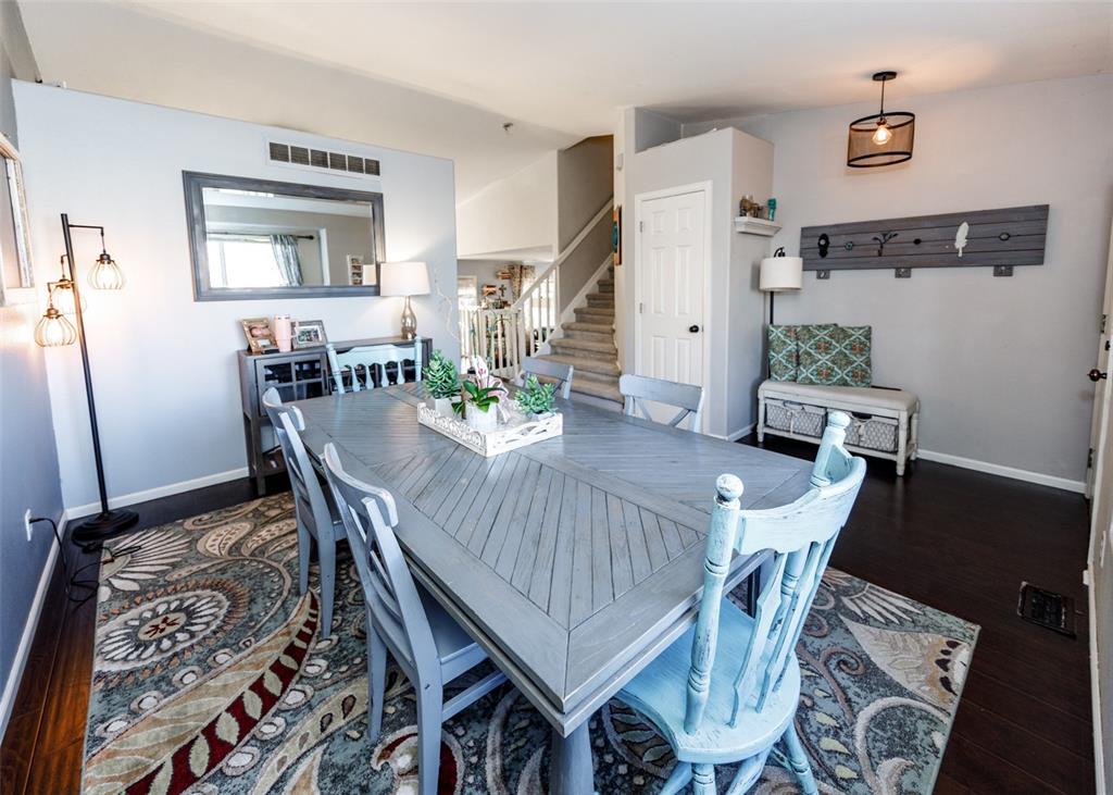 Image 10 of 42: Dining area with dark wood-style floors and stairs