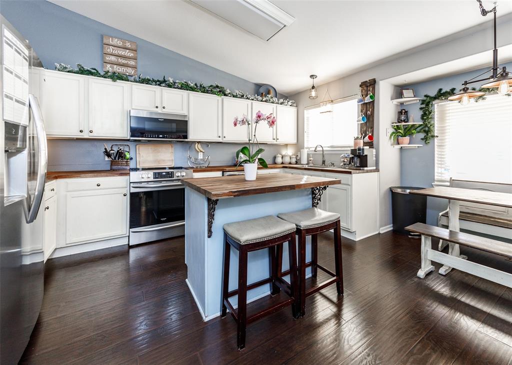 Image 12 of 42: Kitchen featuring wooden counters, white cabinets, stainless steel applianc
