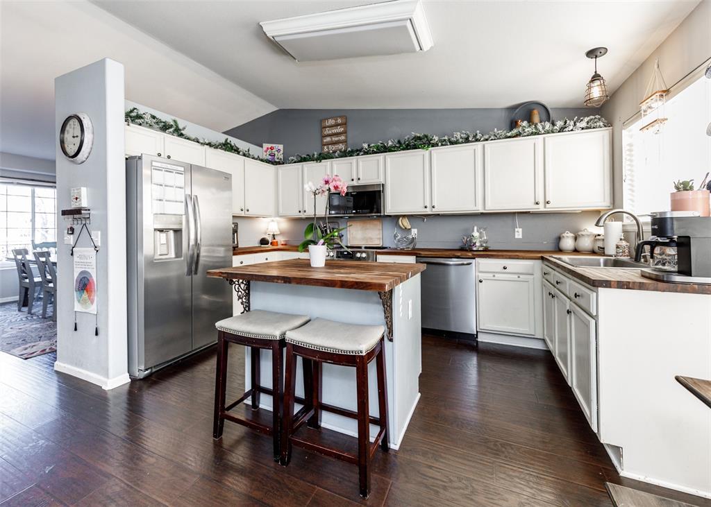 Image 14 of 42: Kitchen with appliances with stainless steel finishes, vaulted ceiling, a b