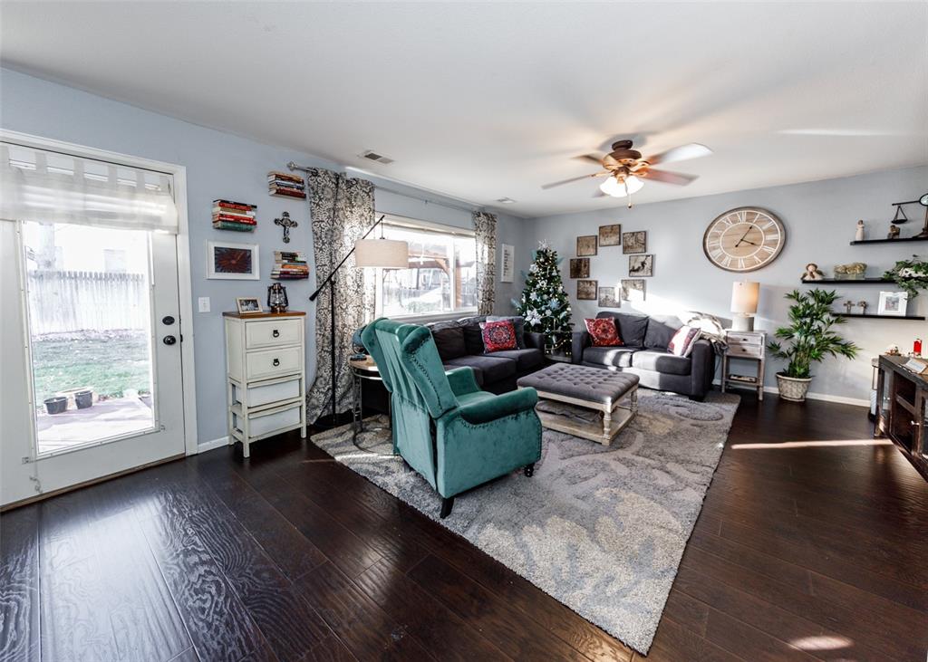 Image 21 of 42: Living room with dark wood-type flooring and a ceiling fan