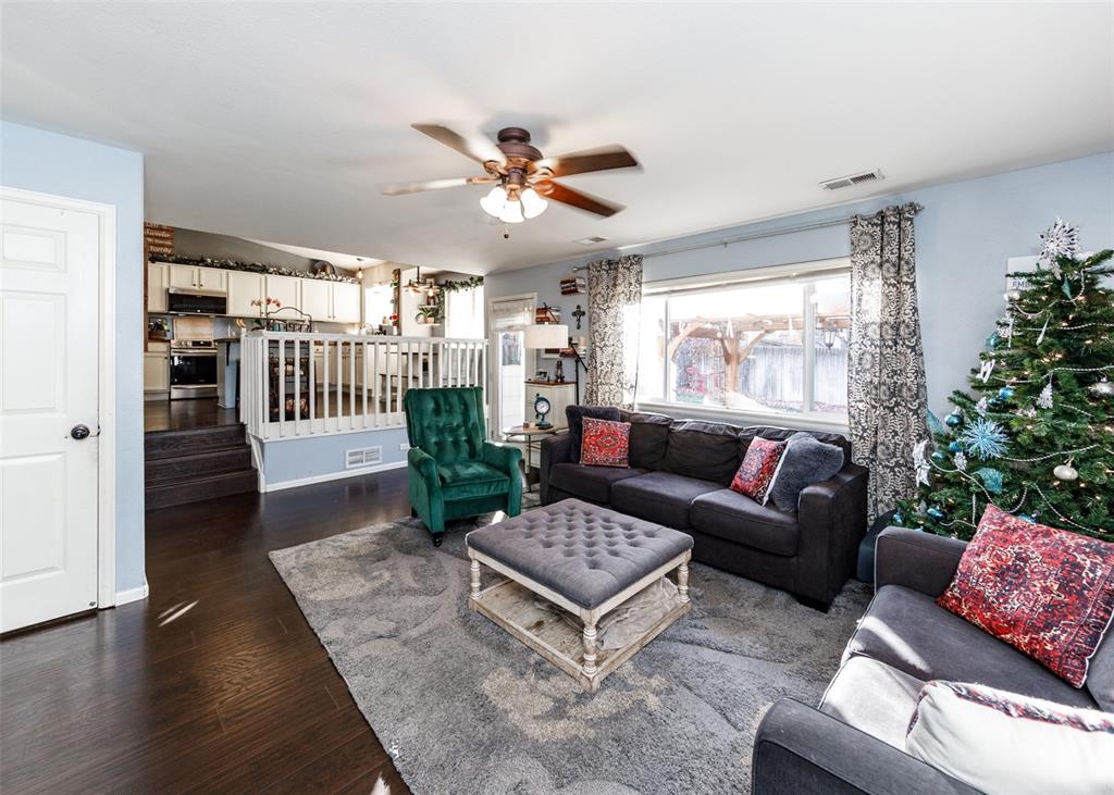 Image 24 of 42: Living area featuring dark wood finished floors and ceiling fan