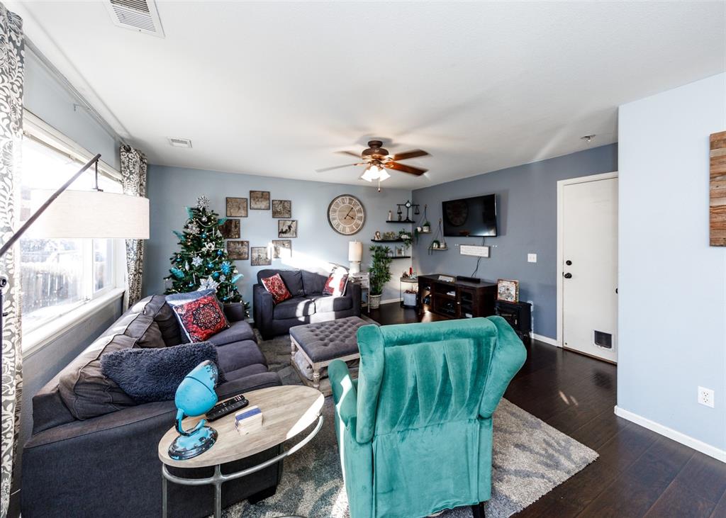 Image 25 of 42: Living room with dark wood-style flooring and ceiling fan