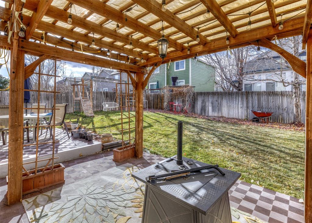 Image 3 of 42: Fenced backyard with a patio area and outdoor dining area
