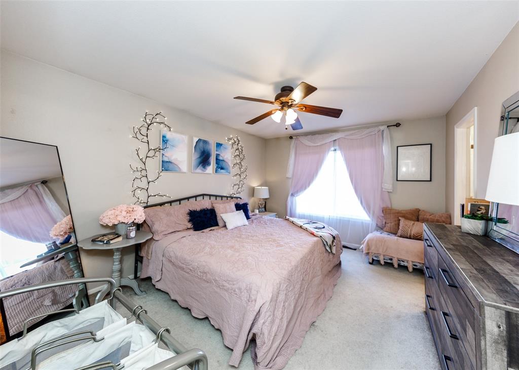Image 32 of 42: Bedroom with light colored carpet and ceiling fan