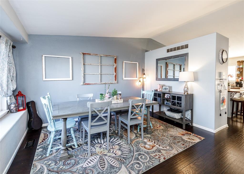 Image 8 of 42: Dining space with dark wood-type flooring and vaulted ceiling