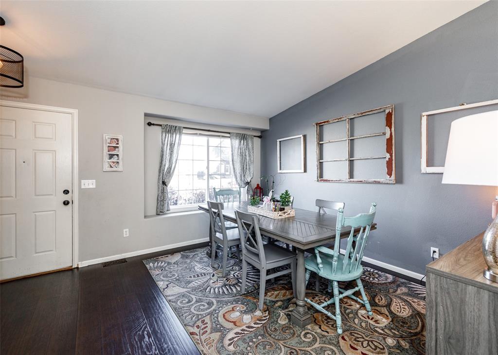 Image 9 of 42: Dining area with dark wood-type flooring and vaulted ceiling