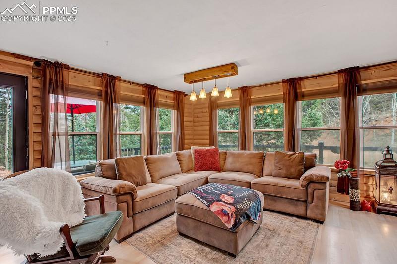 Image 12 of 27: Living room featuring light wood-style floors and healthy amount of natural
