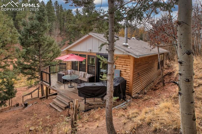 Image 2 of 27: Back of house featuring a wooden deck, faux log siding, board and batten si