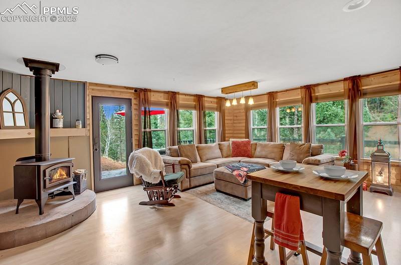 Image 20 of 27: Living room featuring a wood stove and light wood-type flooring