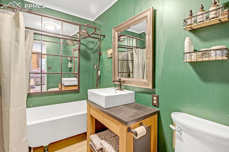 Image 24 of 27: Bathroom featuring toilet, a tub to relax in, and vanity