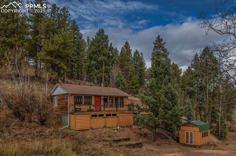 Image 4 of 27: View of shed with a wooded view