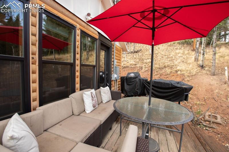 Image 9 of 27: Wooden deck with outdoor lounge area, outdoor dining area, and a grill