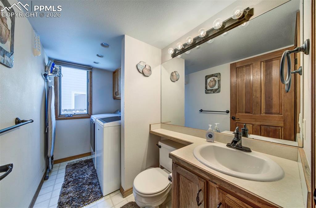 Image 18 of 38: Main level half bath with washer and dryer that stay with home