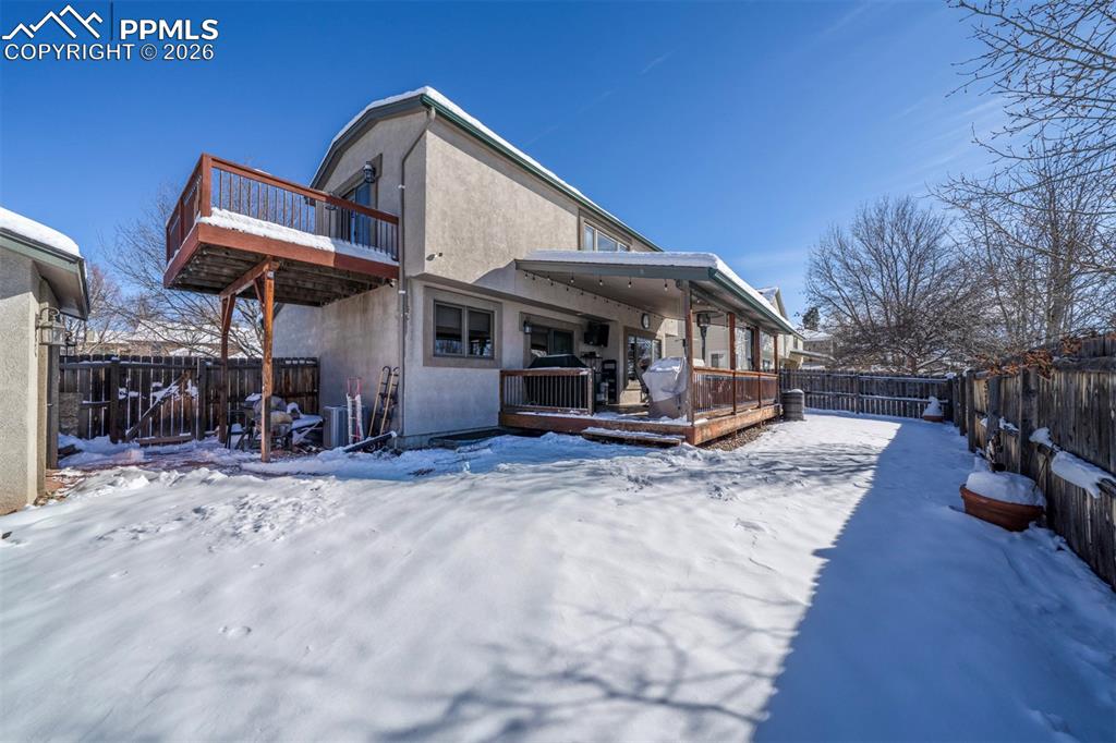 Image 32 of 38: Side view of backyard with covered patio, primary bedroom walk out to deck,