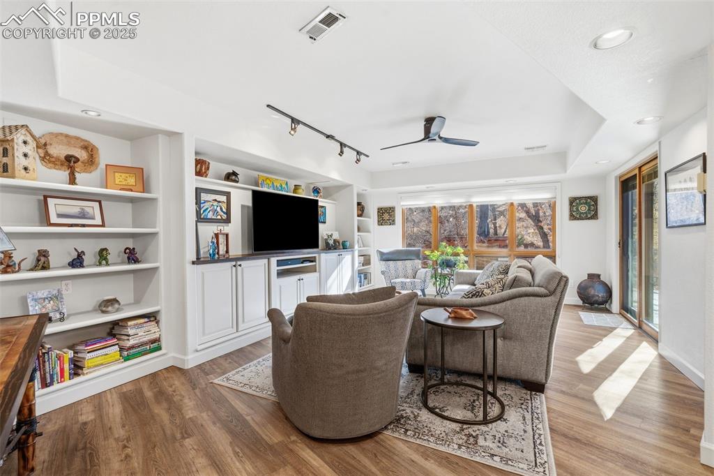 Image 9 of 46: Family Room with built-in shelving and entertainment center opens to one of
