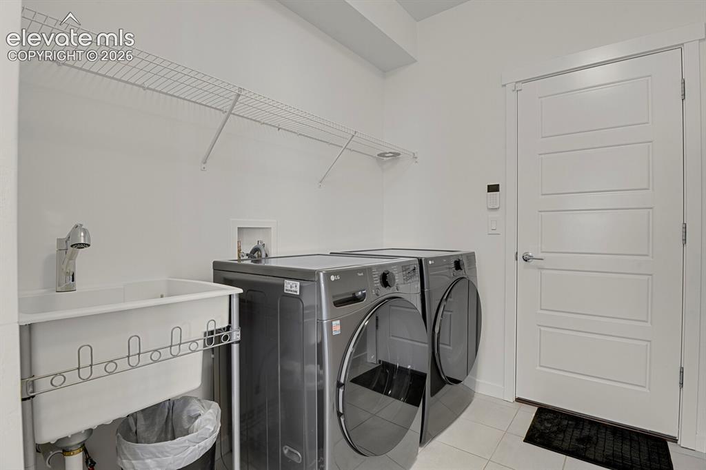 Image 29 of 44: Main level laundry room with utility sink.